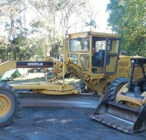 A Yellow Caterpillar Tractor Is Parked Next to A Bulldozer — Roll Formed Driveways in Yandina, QLD