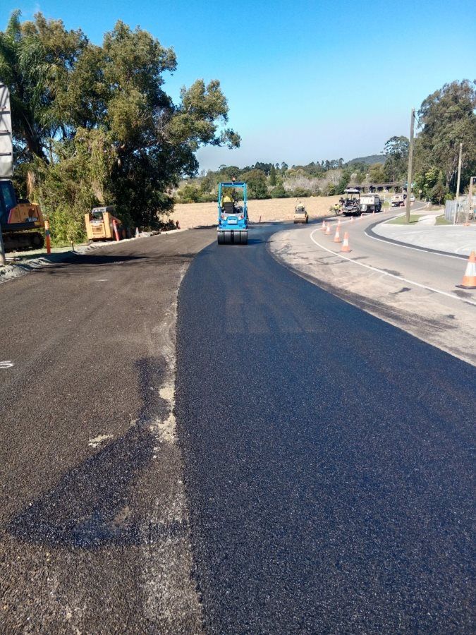 A Truck Is Driving Down A Road That Is Being Paved — Roll Formed Driveways in Nambour, QLD