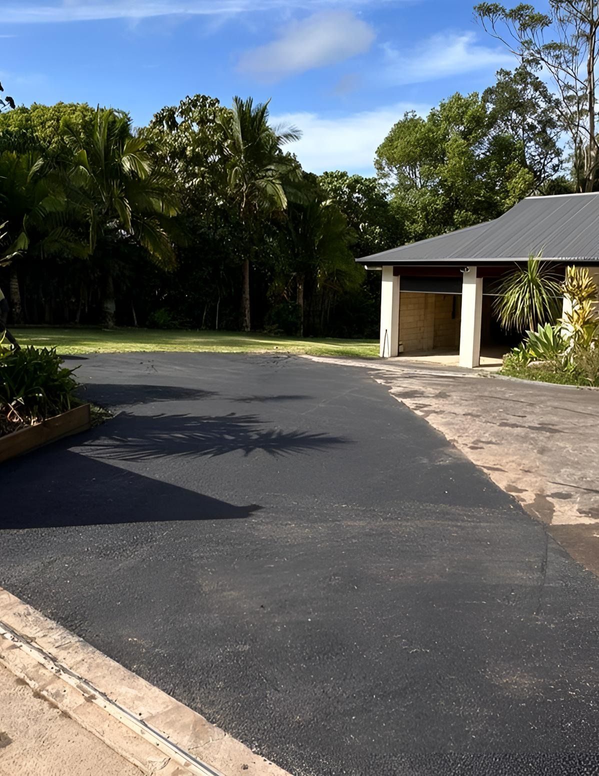 A Driveway Leading To A House With Palm Trees In The Background — Roll Formed Driveways in Yandina, QLD