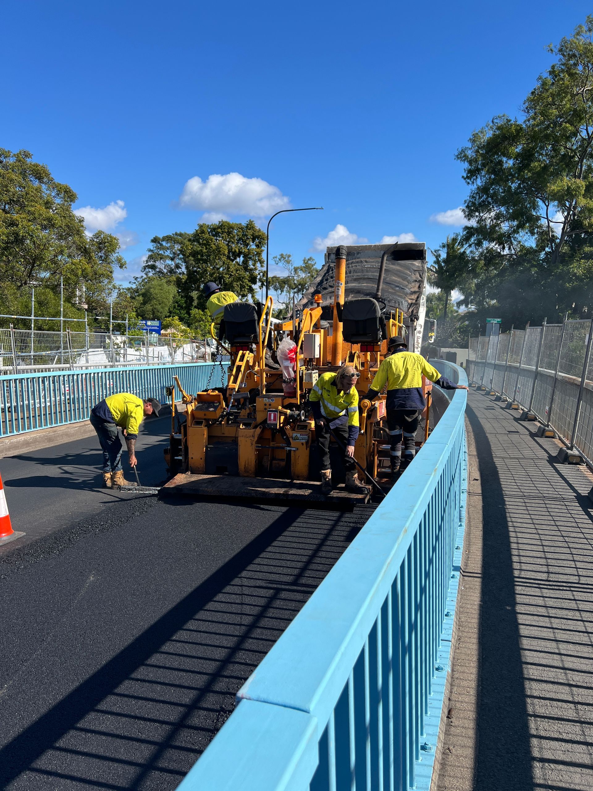 A Group Of Construction Workers Are Working On A Bridge — Roll Formed Driveways in Sunshine Coast, QLD
