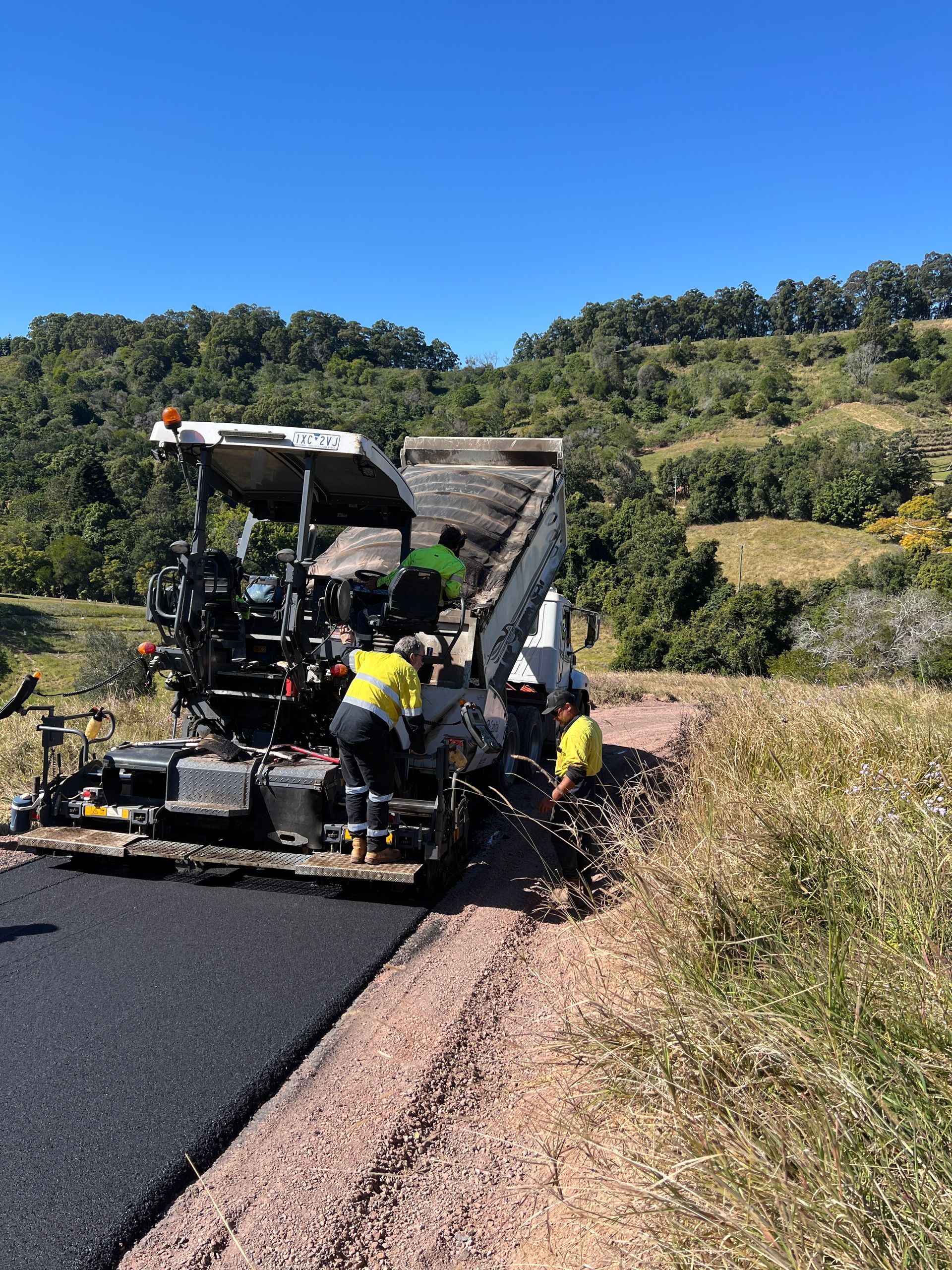 A Group Of People Are Working On A Road — Roll Formed Driveways in Yandina, QLD