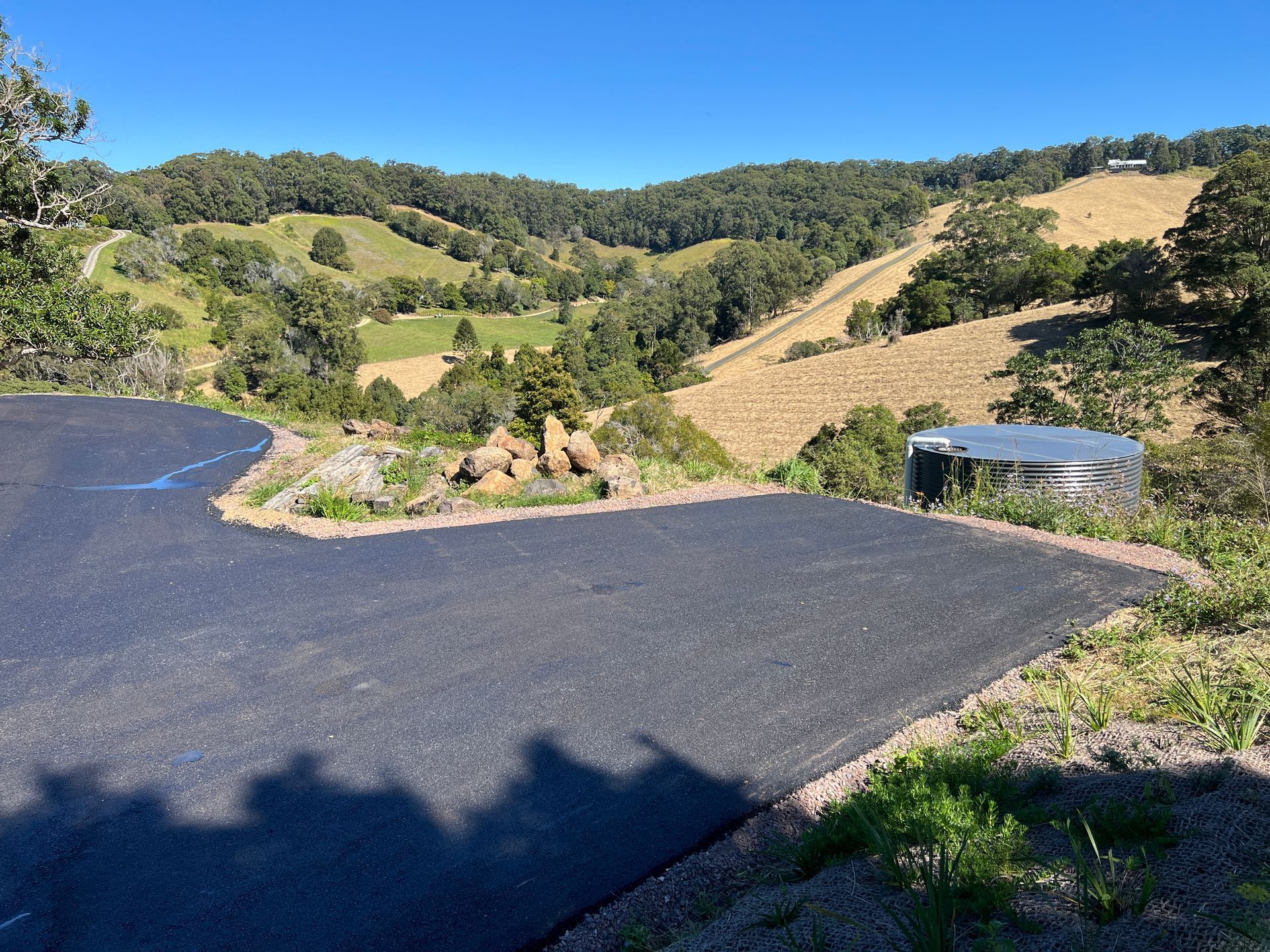 Winding Asphalt Road Overlooks Rolling Green Hills