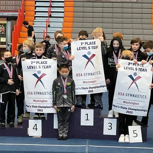 A group of children are standing on a podium holding signs.