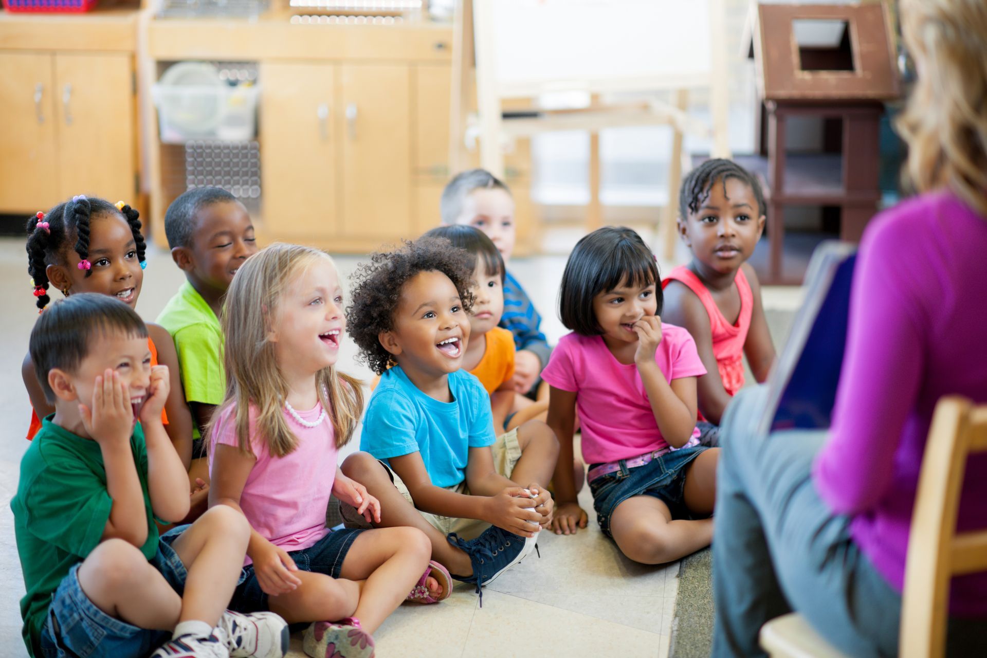 A group of young girls in pajamas are standing next to each other in a classroom.