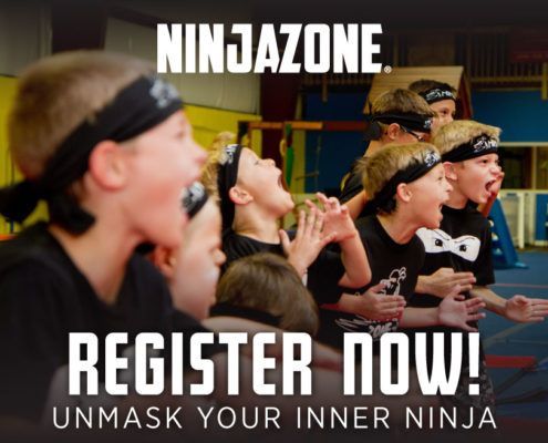 A group of children wearing headbands are sitting in a gym.