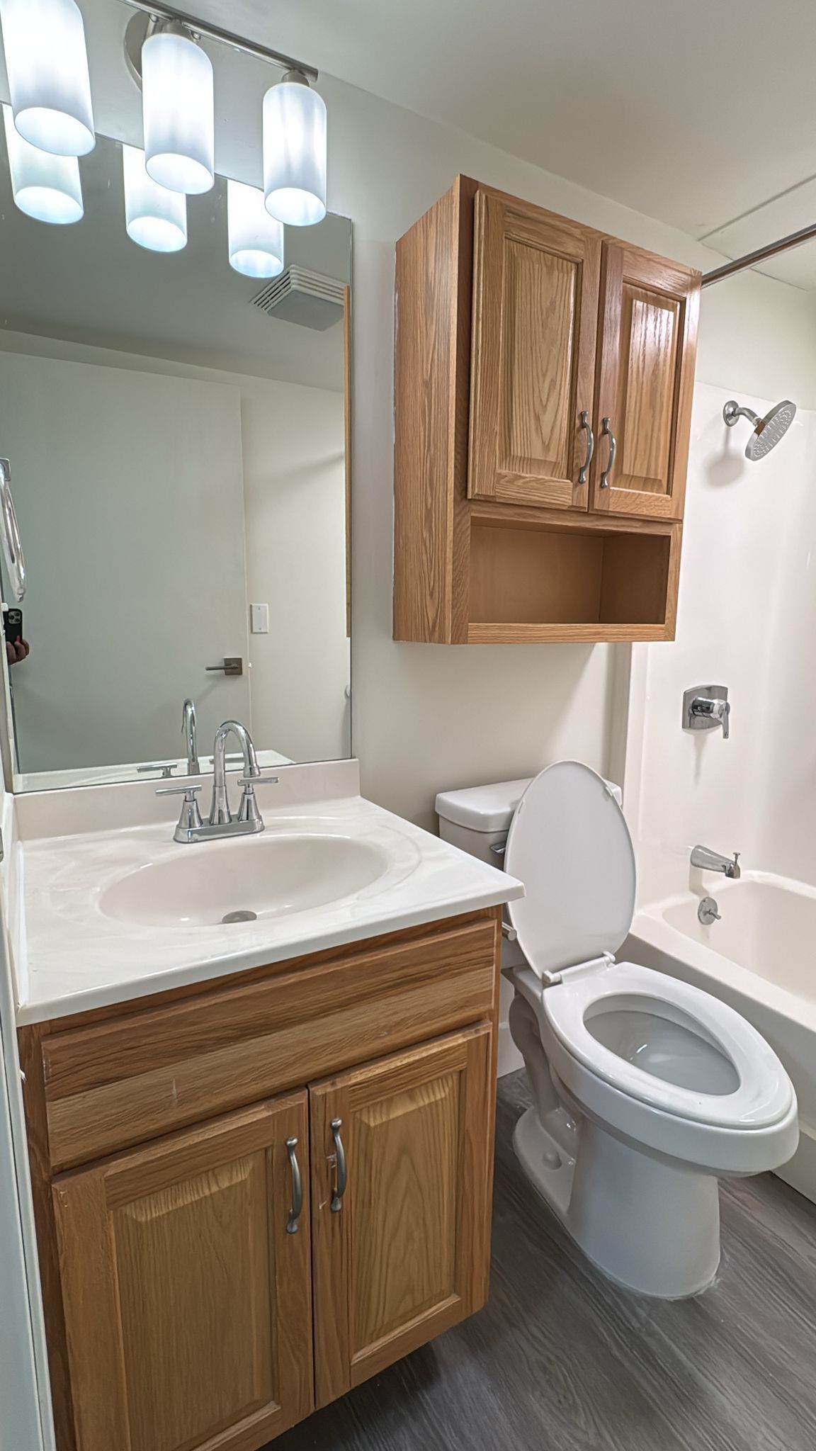A bathroom with a sink , toilet , bathtub and mirror.