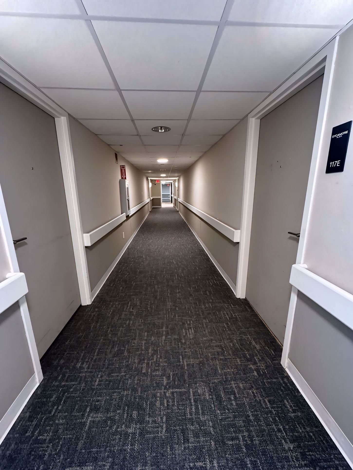 A long hallway with a sign on the wall that says tk