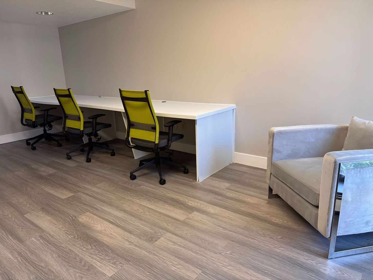 A room with three desks and chairs and a chair.