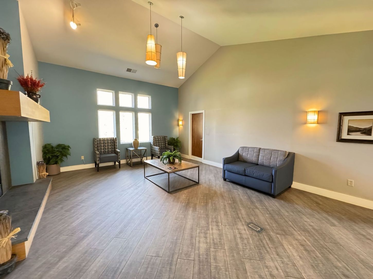 A living room with a couch , chairs , coffee table and fireplace.