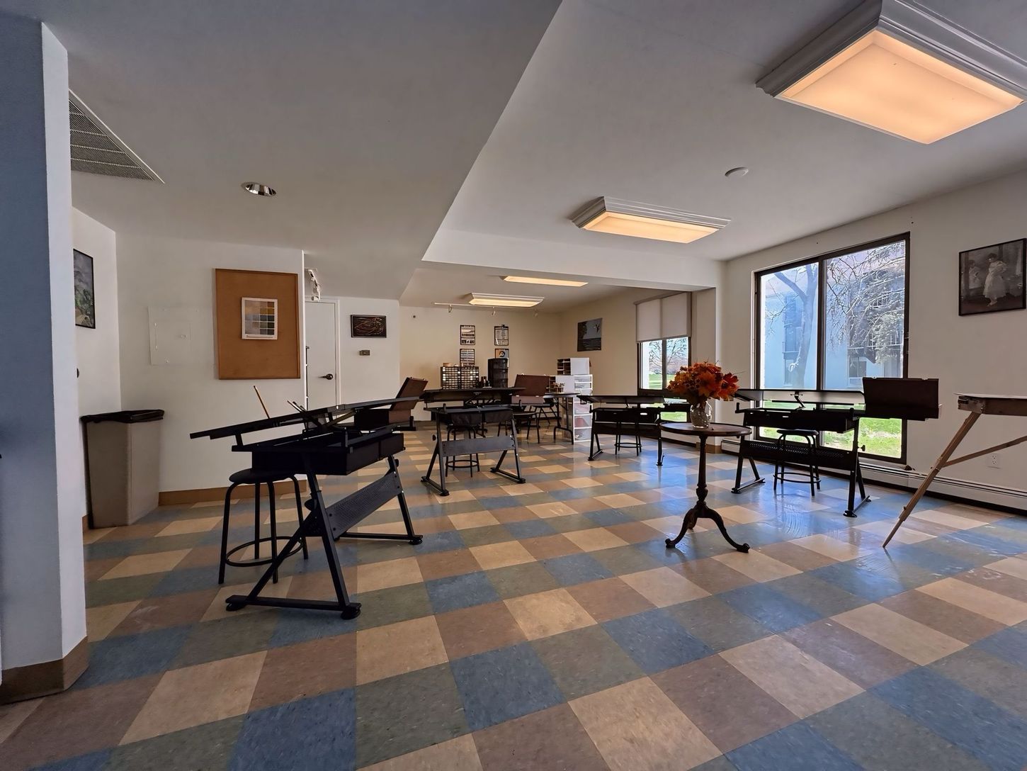 A large room with tables and chairs and a checkered floor