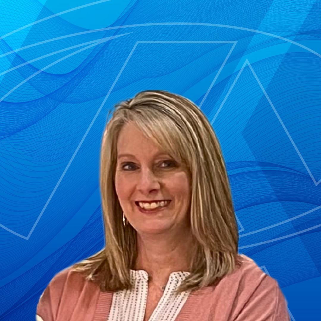 A woman is smiling in front of a blue background