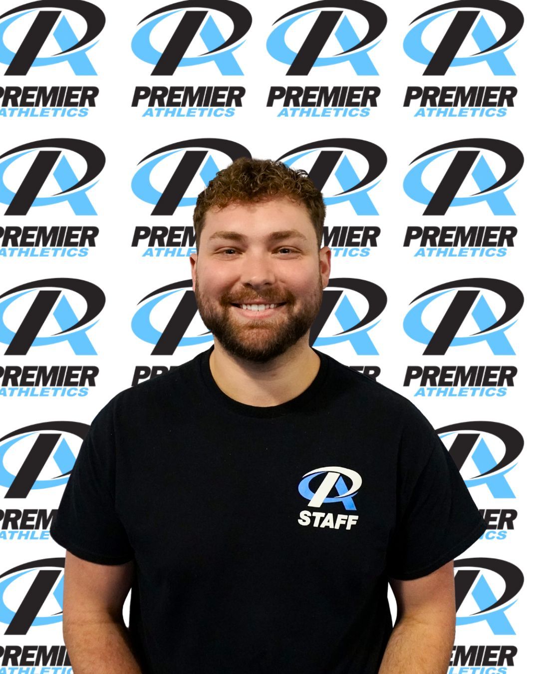 A woman wearing a premier athletics shirt smiles for the camera