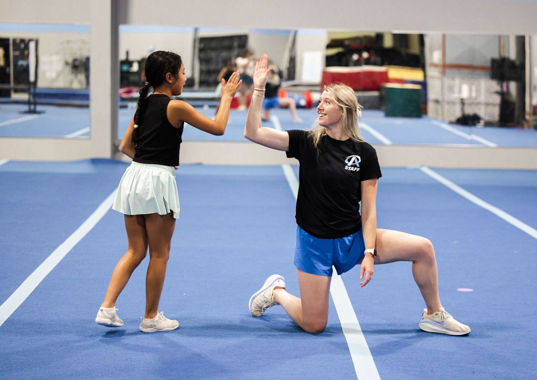 A boy wearing a green hat and a girl wearing a pink skirt