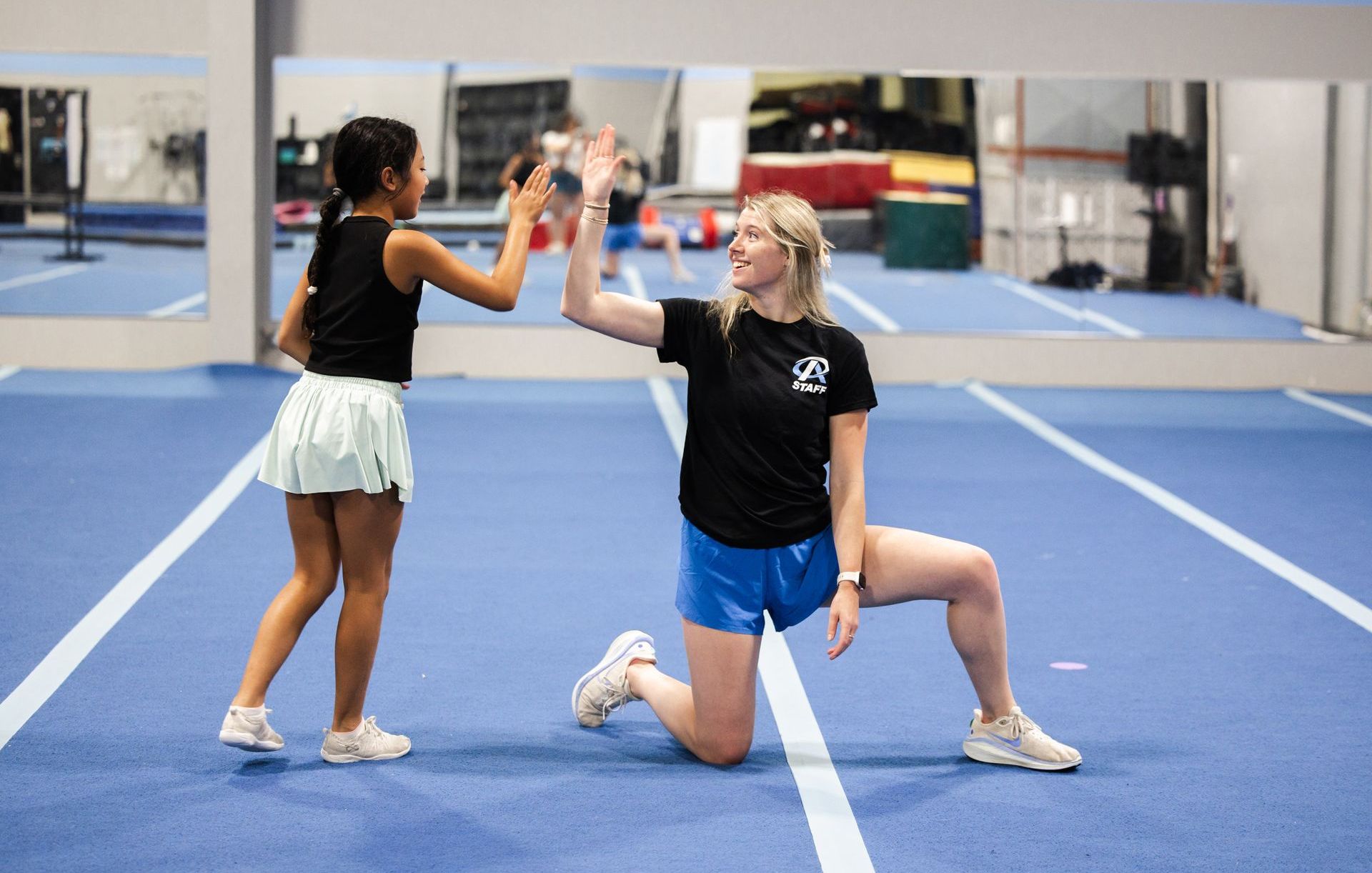 A young girl is doing a handstand and smiling