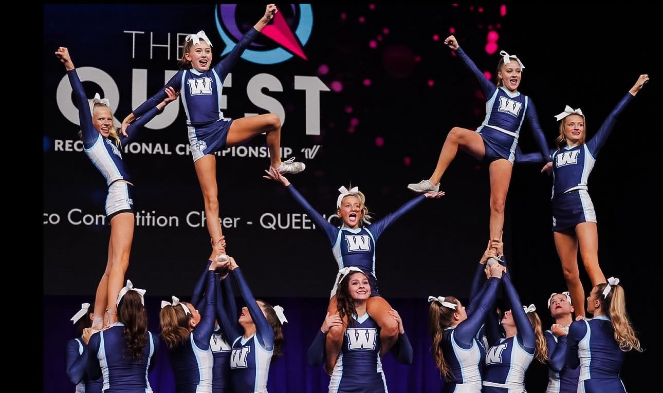 A cheerleader wearing a wilco uniform is holding pom poms
