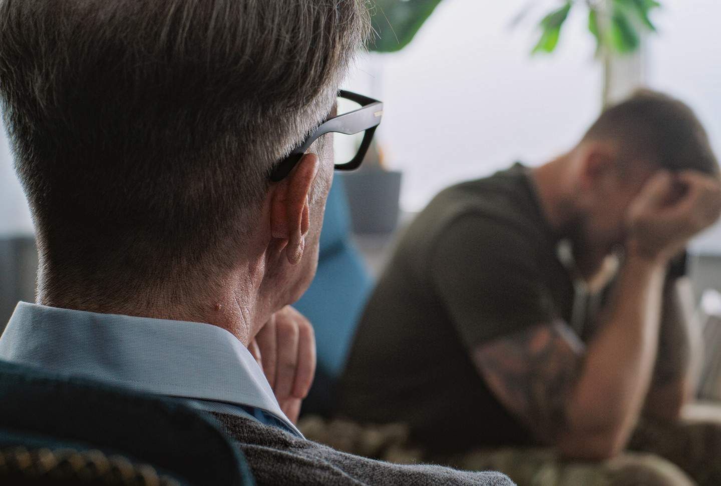 Therapist facing a distressed person. They are in an office setting.