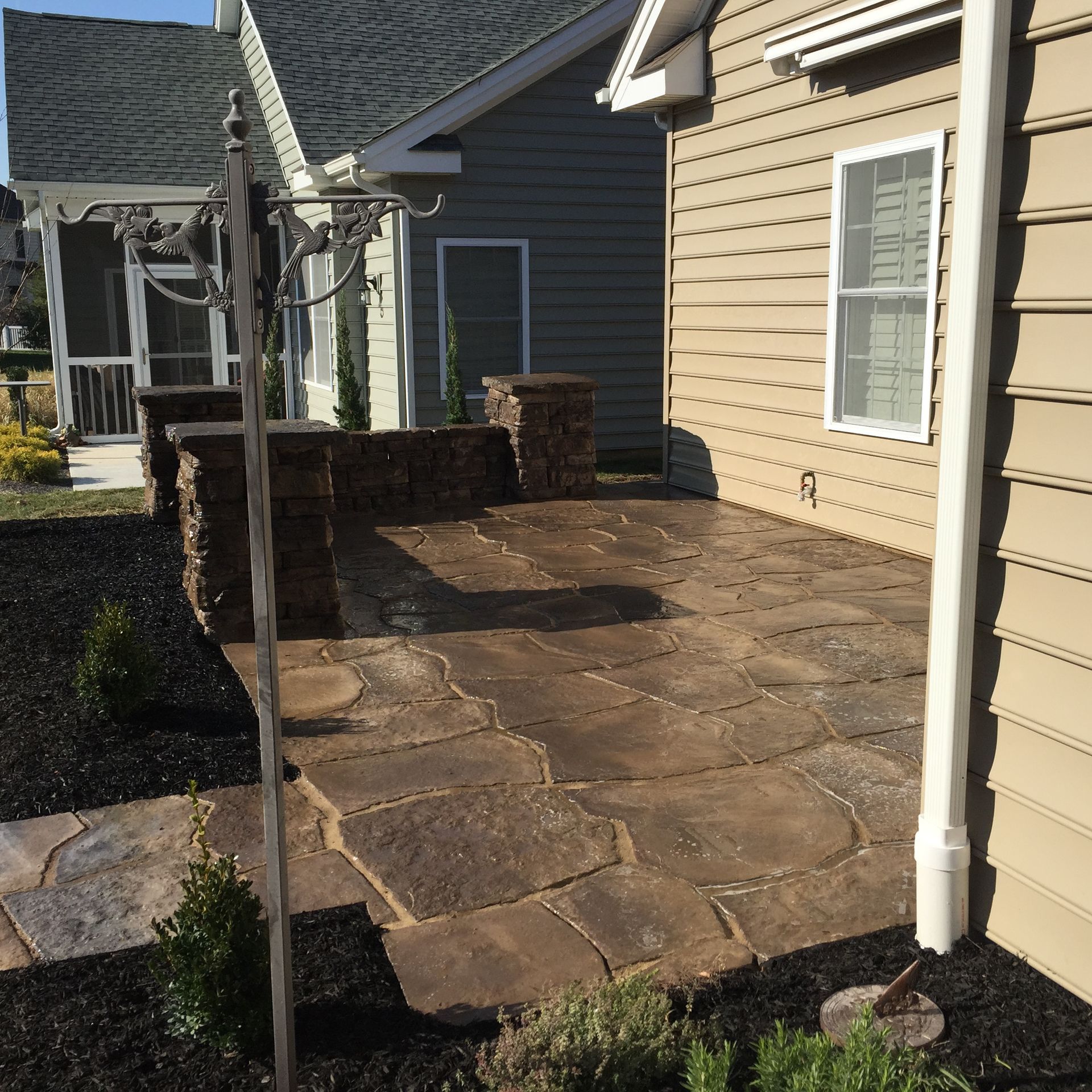 A house with a stone patio in front of it