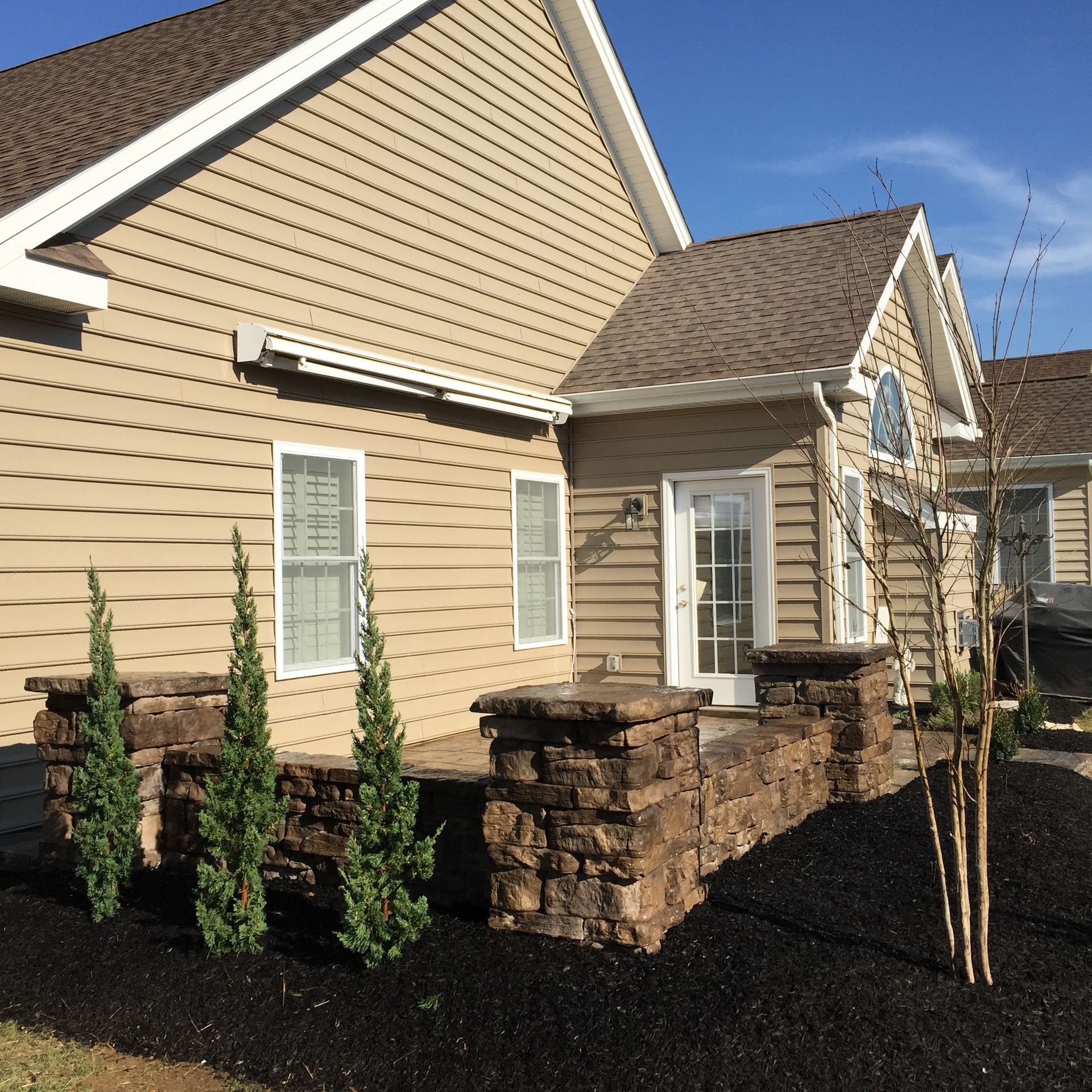 A house with tan siding and a brown roof