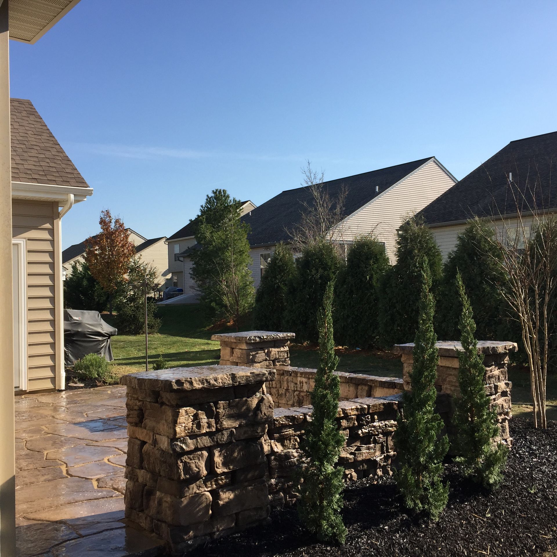 A house with a stone wall in front of it