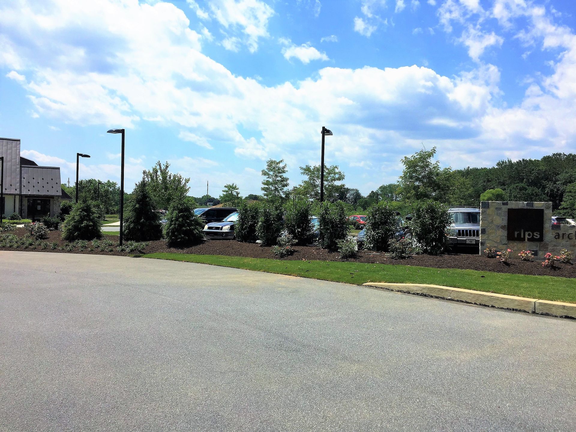 A parking lot with cars parked in front of a building