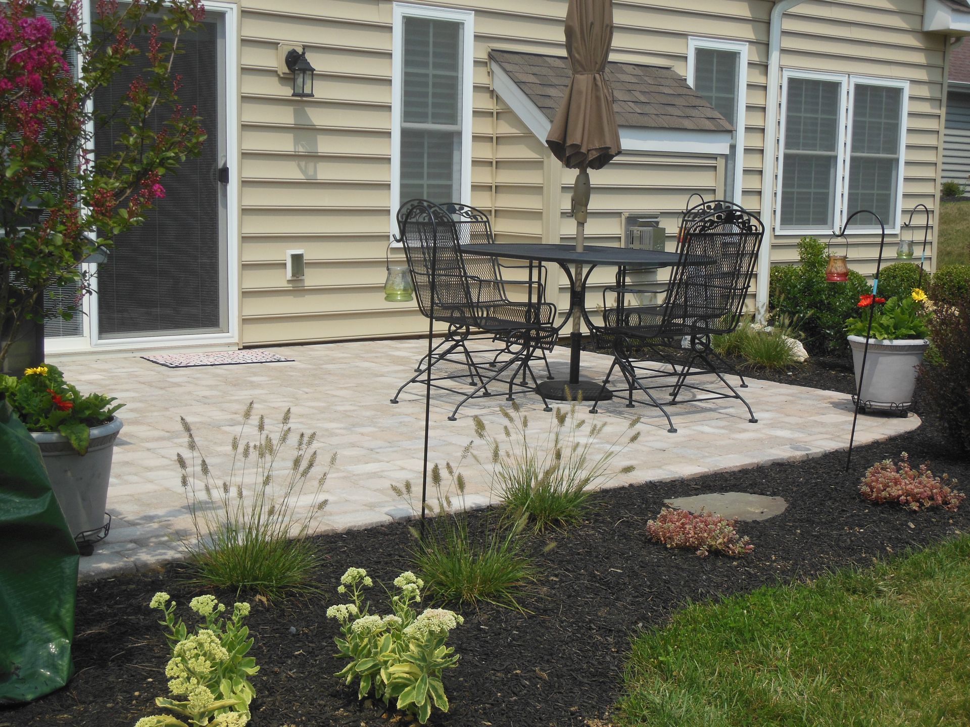 A patio with a table and chairs in front of a house
