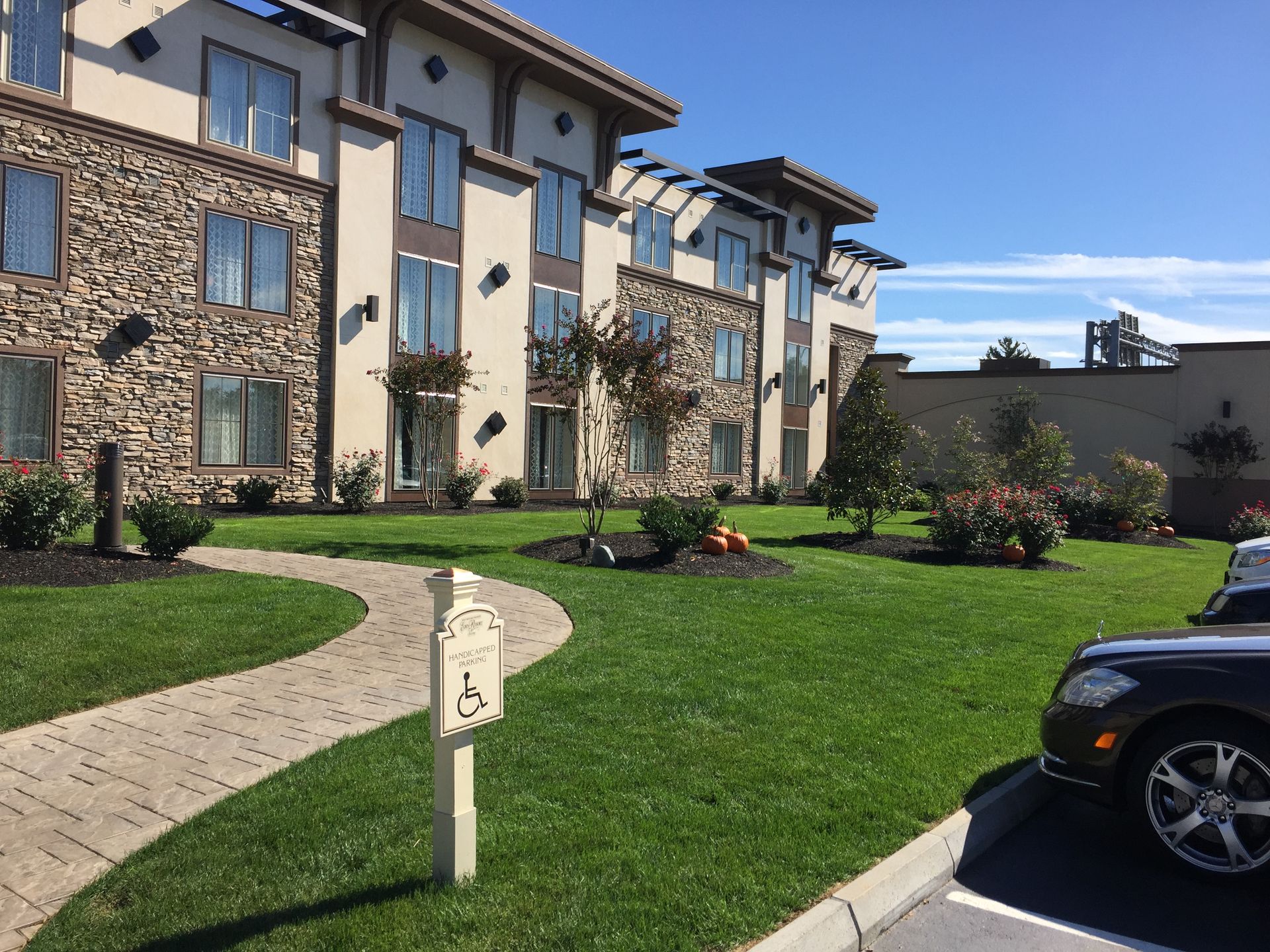 A car is parked in front of a large apartment building