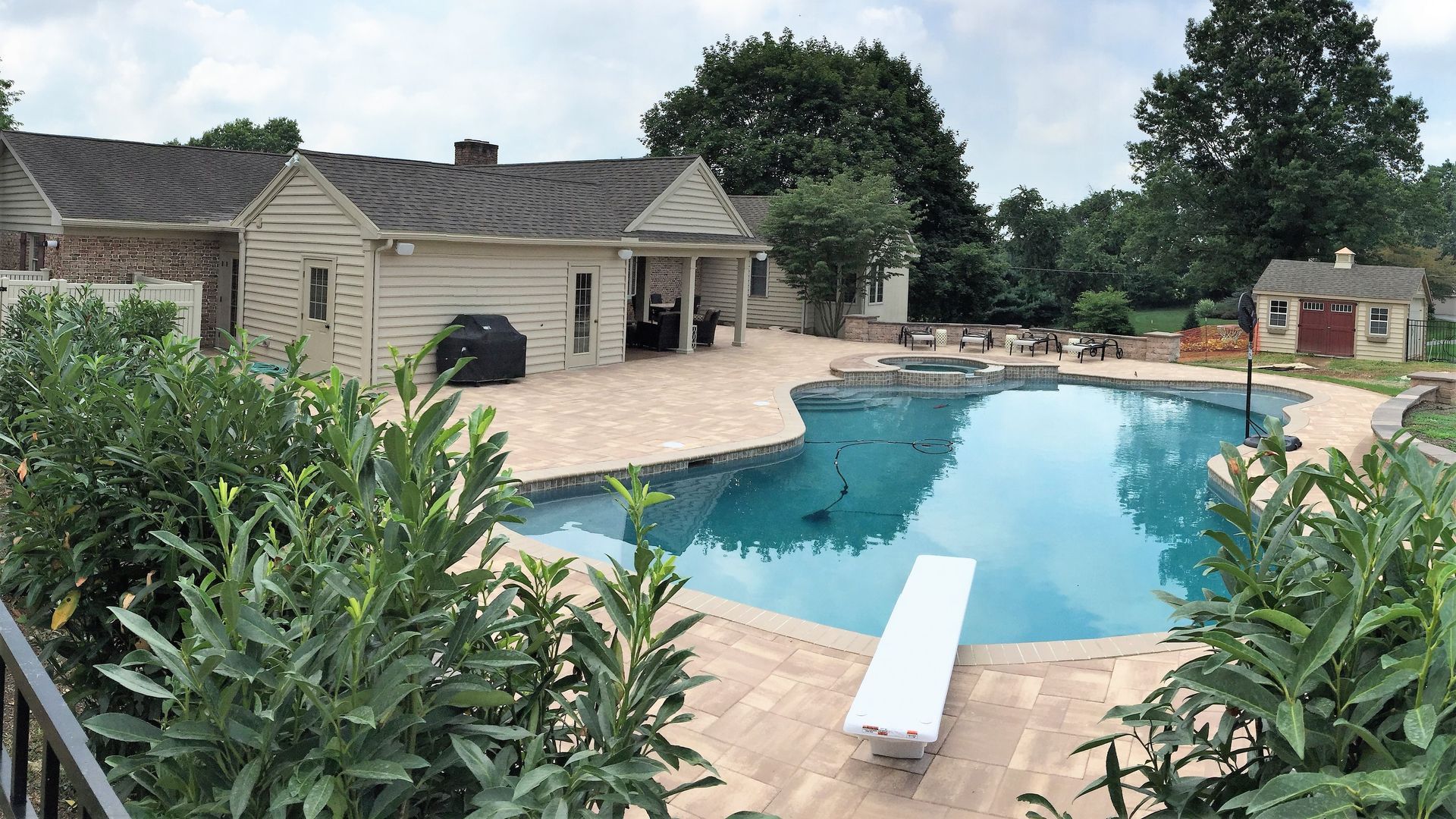 There is a large swimming pool in the backyard of a house.
