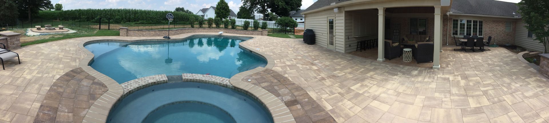 There is a large swimming pool in the backyard of a house.