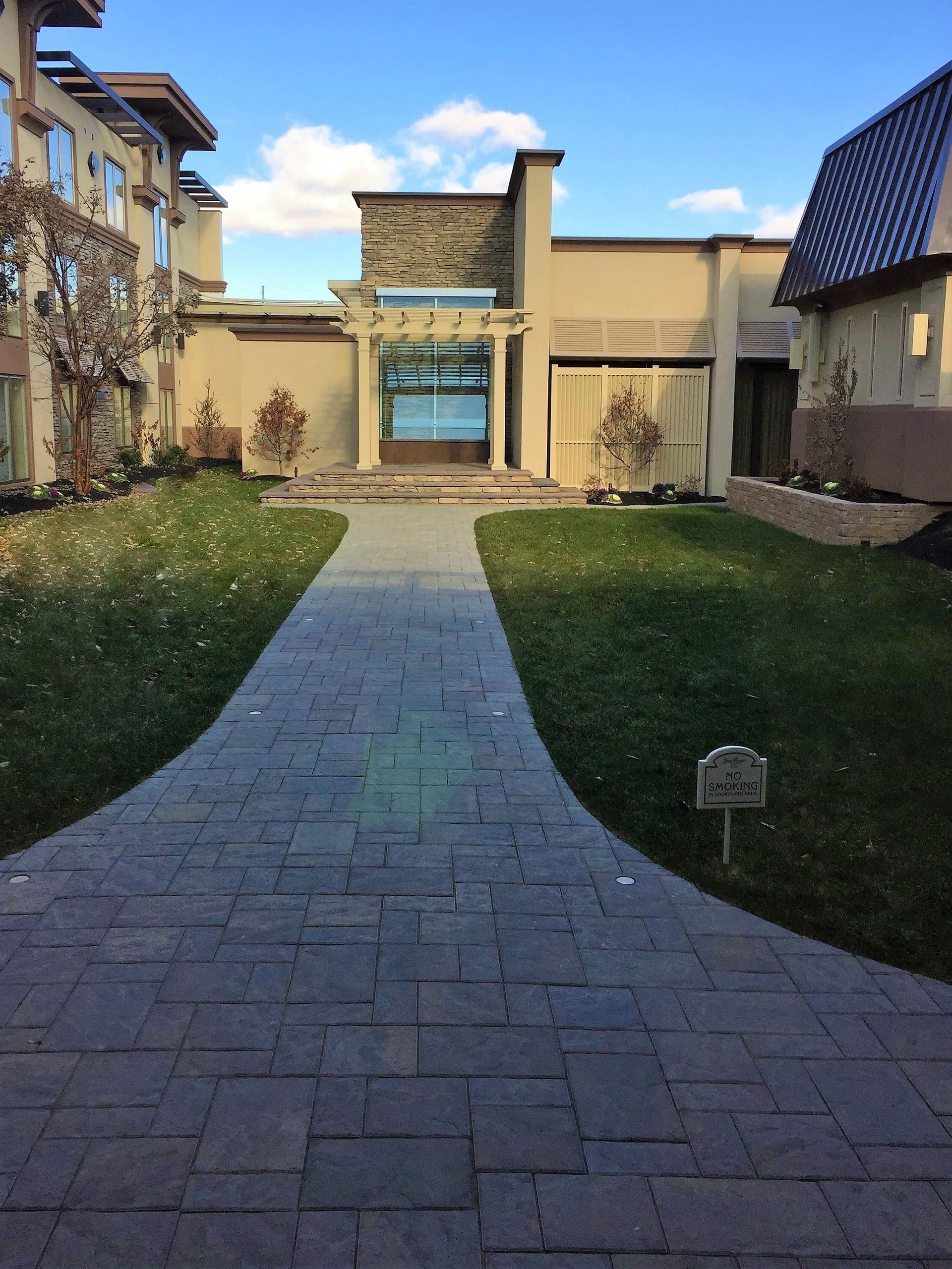 A brick walkway leads to a large building