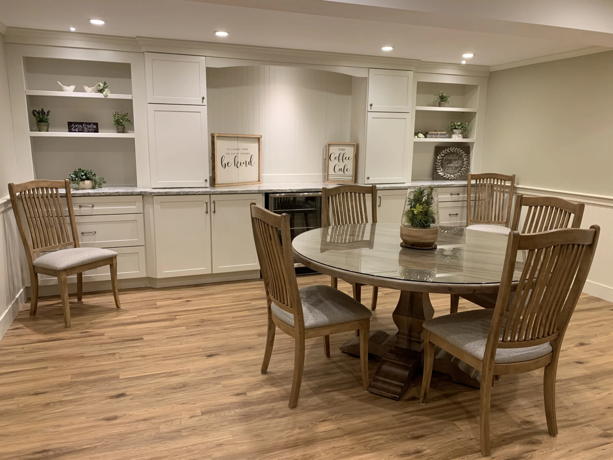 A dining room with a table and chairs in a basement.