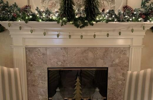 A fireplace with a mantle decorated for christmas.