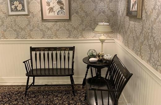 There is a bench and a table in the corner of the room.