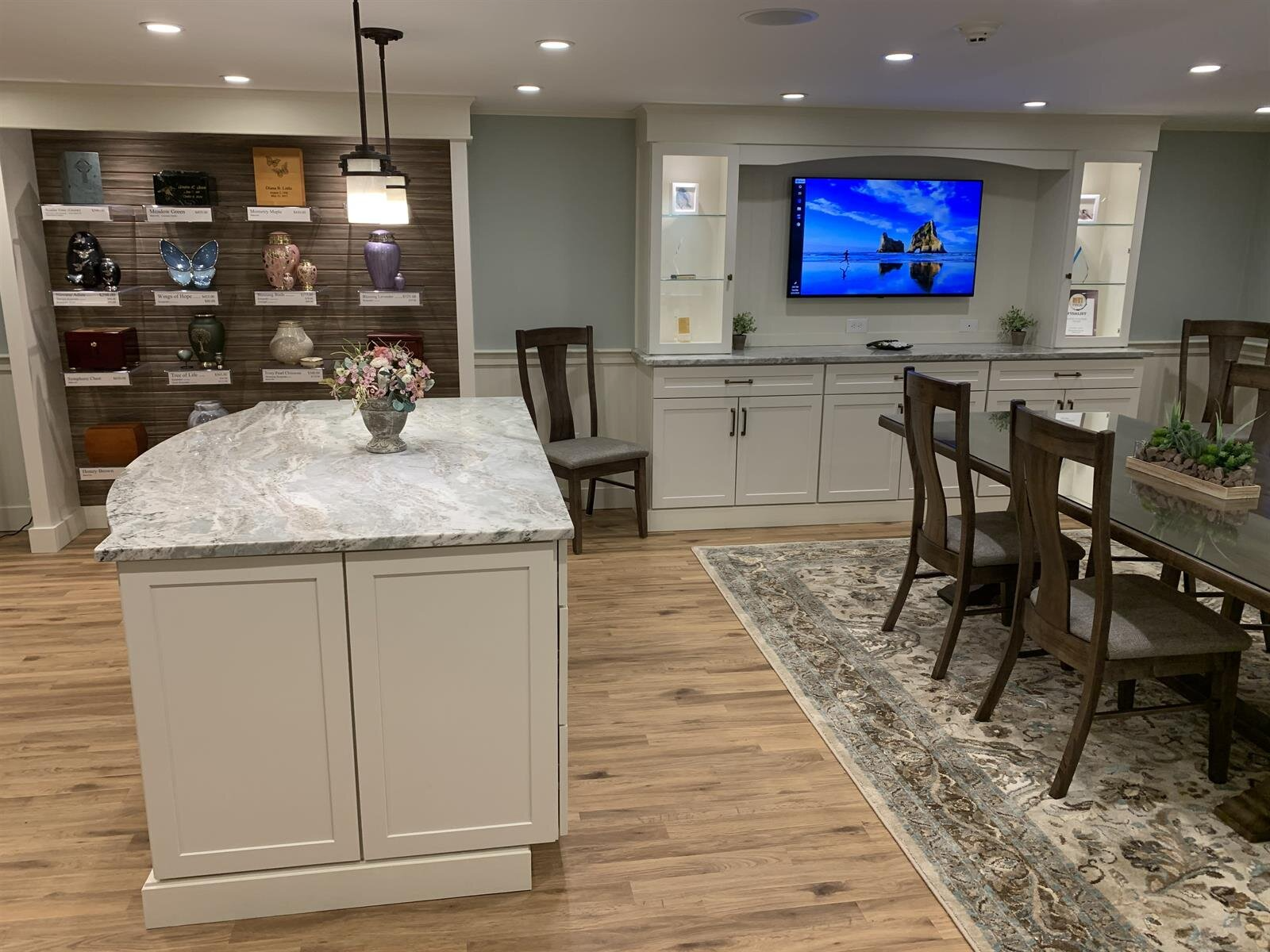 A kitchen with a large island and a television on the wall.