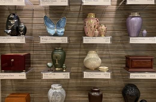 A display of urns and vases on shelves in a store.
