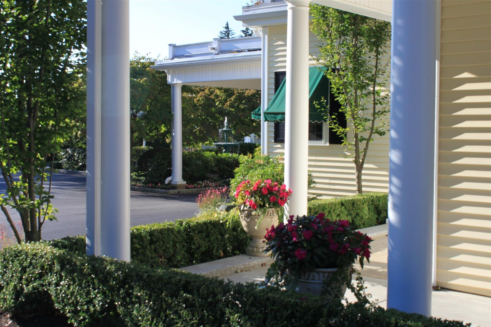 A white house with a porch and flowers in front of it