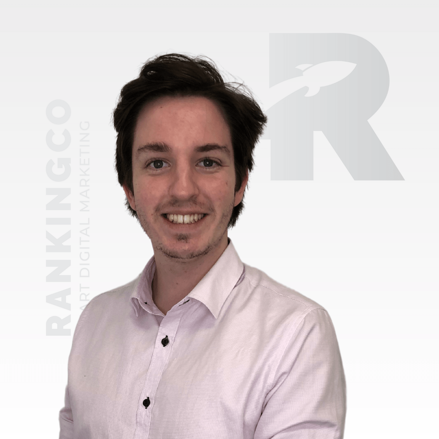 A man in a white shirt is smiling in front of a white background with the letter r on it