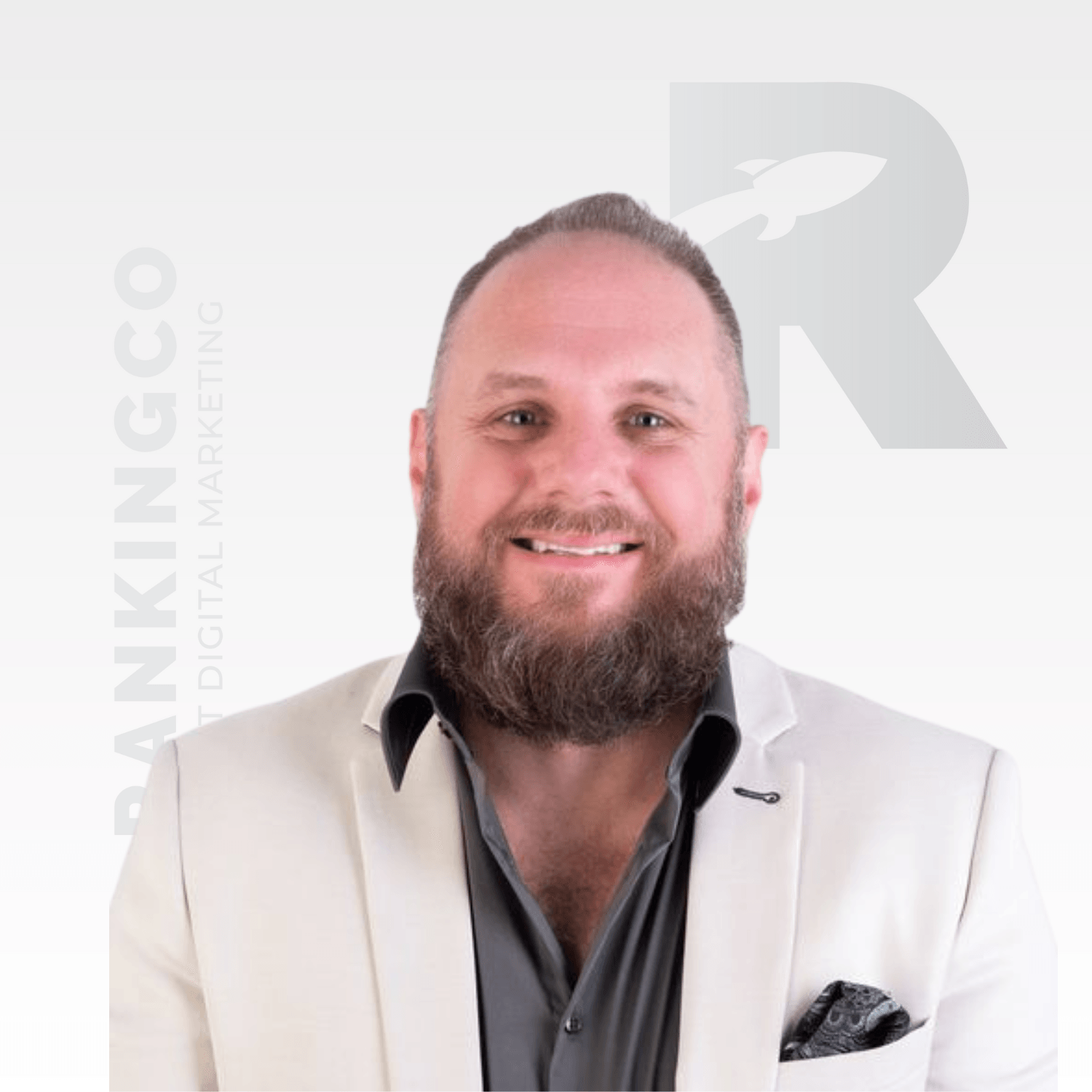 A man with a beard is wearing a white jacket