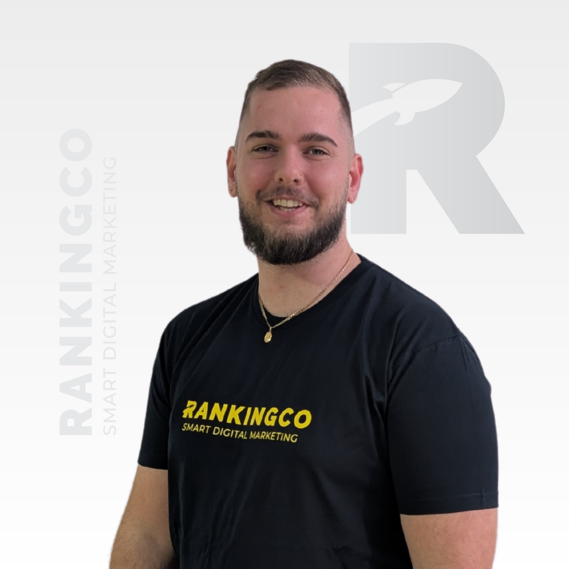 A man with a beard is wearing a white polo shirt