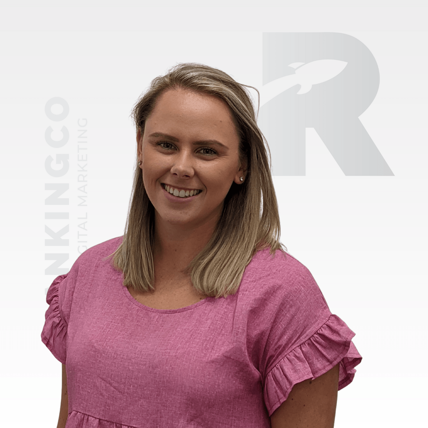 A woman in a pink dress is smiling for the camera
