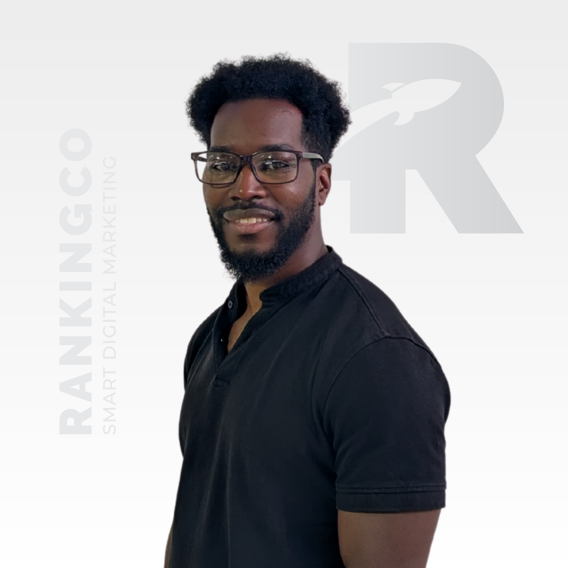 A man wearing glasses and a black shirt stands in front of a white background that says rankingco