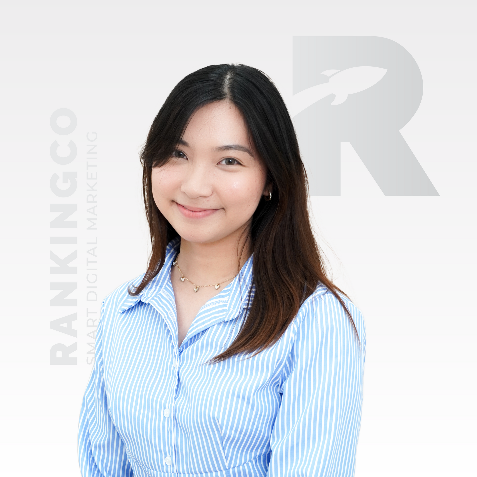 A woman in a blue striped shirt is smiling for the camera