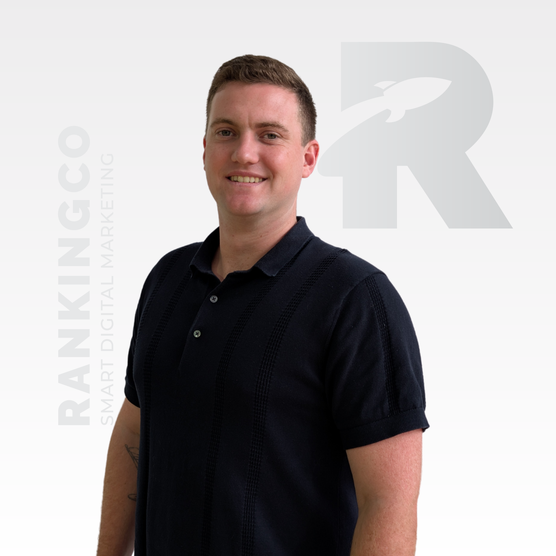 Man in navy polo shirt smiles, with 