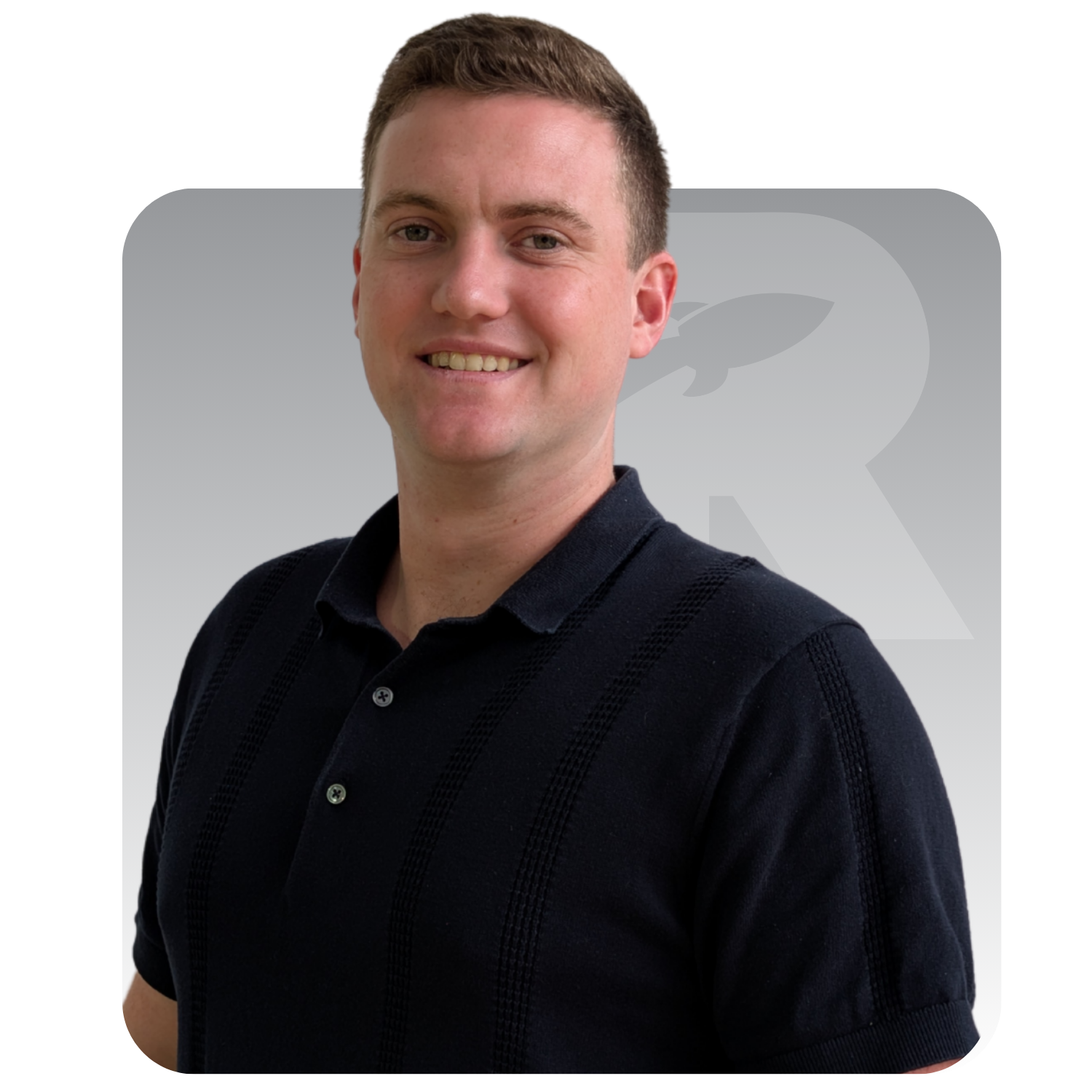 Man in navy polo shirt smiles, with