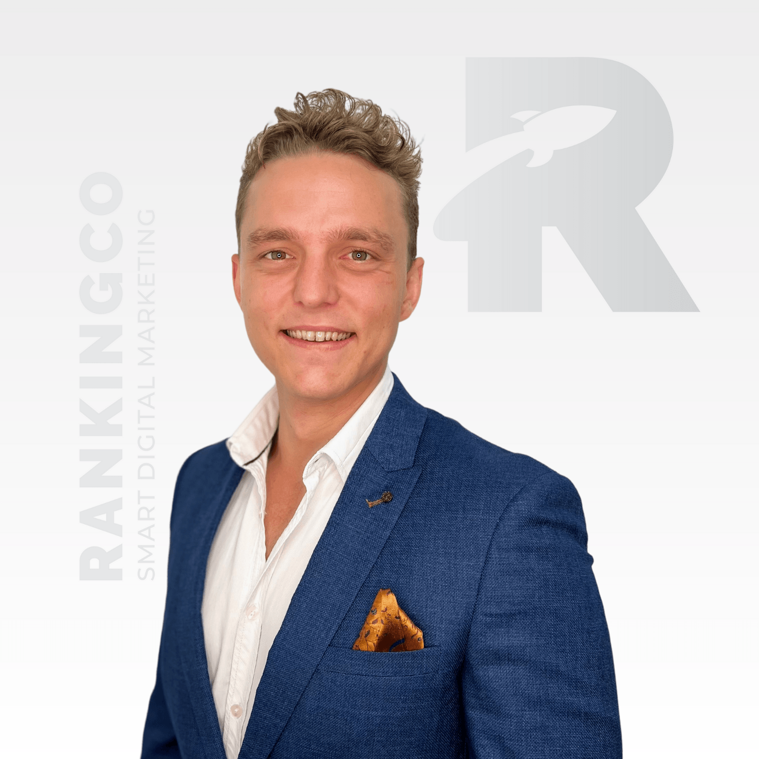 A man in a blue suit and white shirt is smiling
