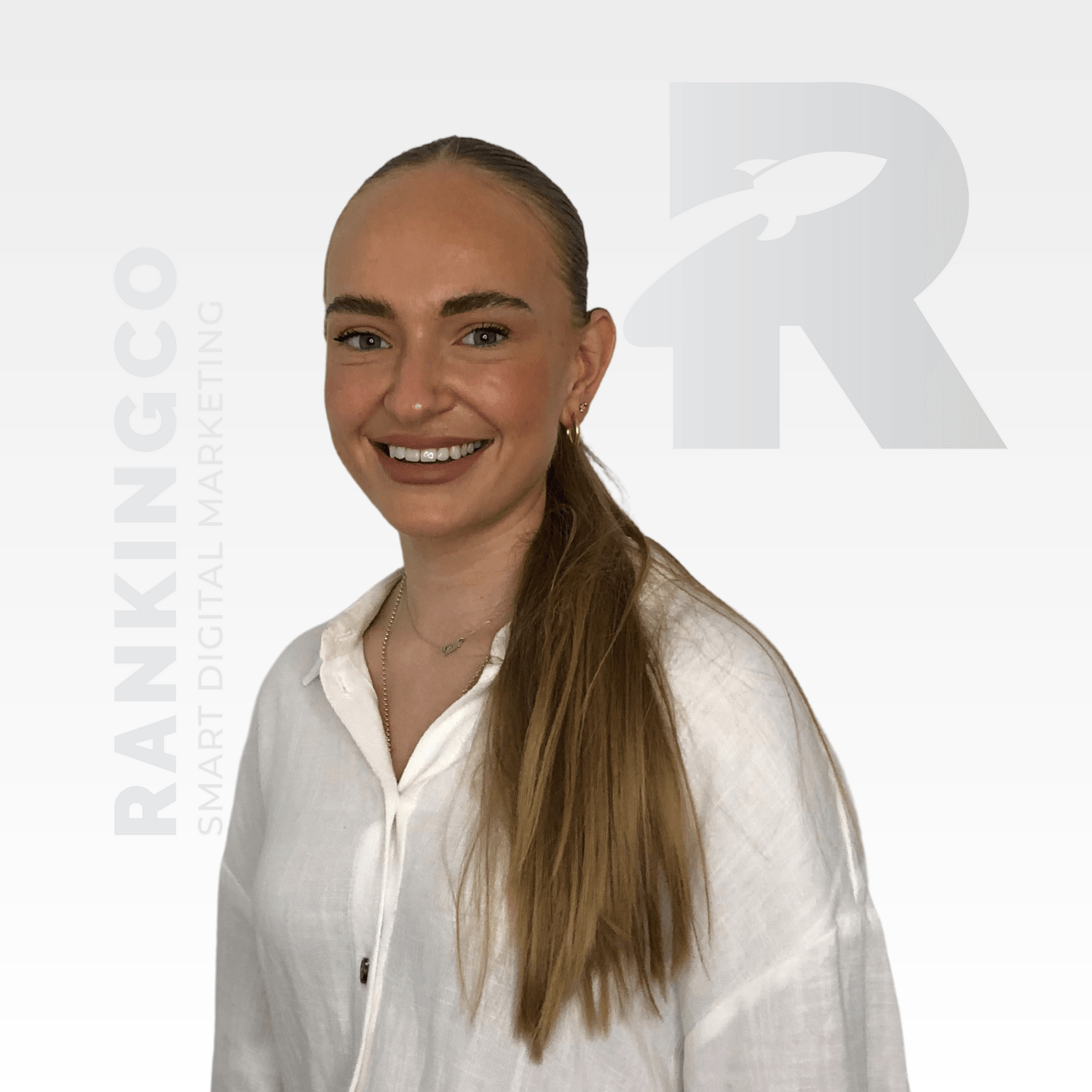 A woman in a white shirt is smiling for the camera