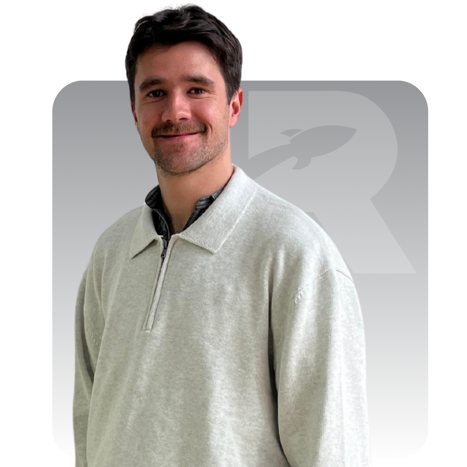 Portrait of a man in a grey sweater against a white background with a faint logo