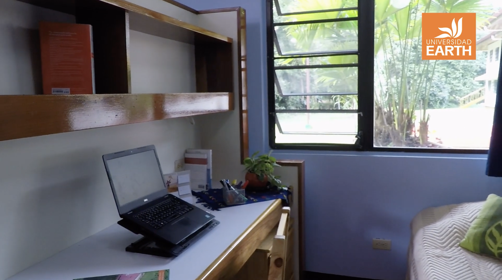 A laptop is sitting on a desk in a room next to a window.