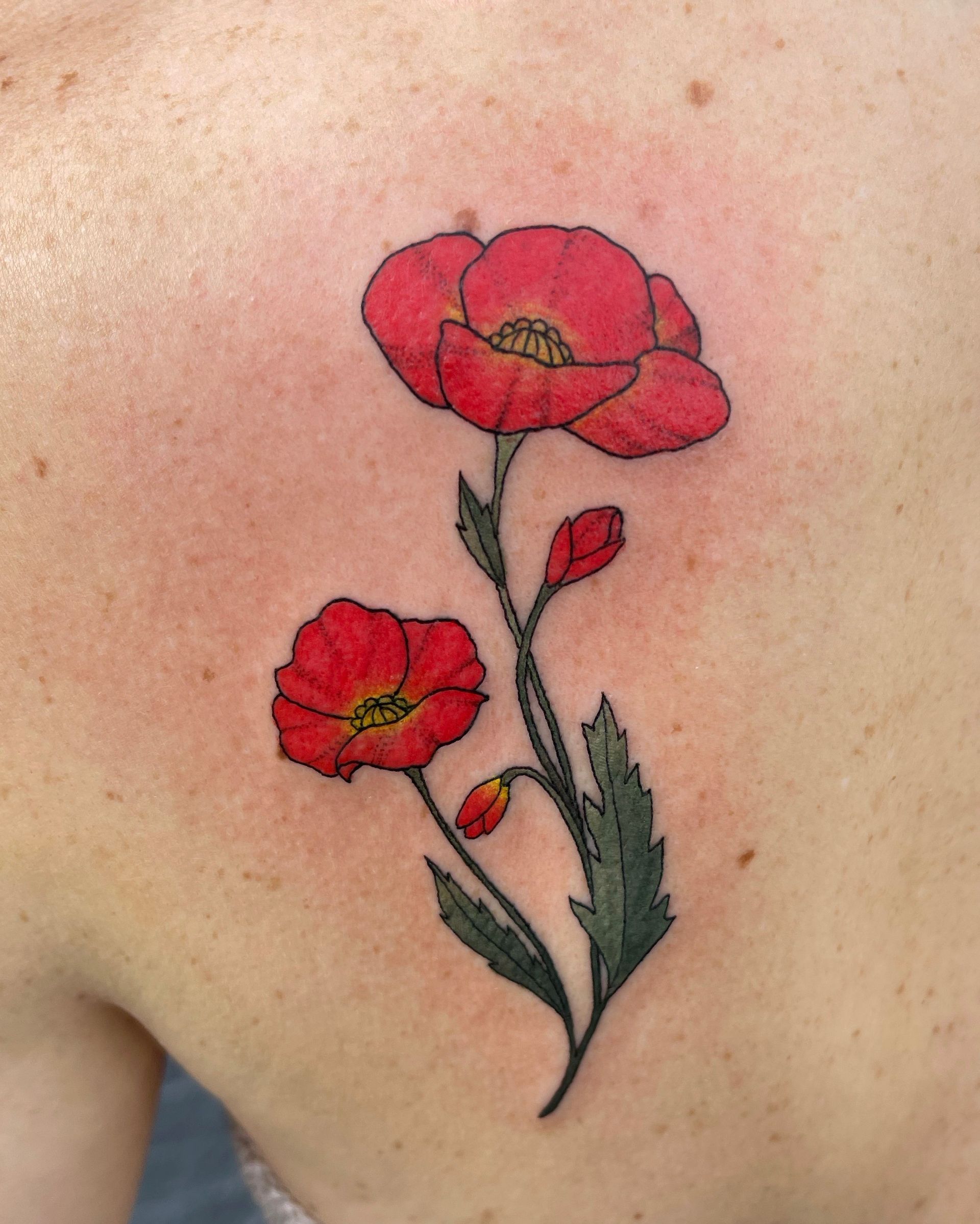Two red poppy flowers tattoo on skin, green stems, and black outline.