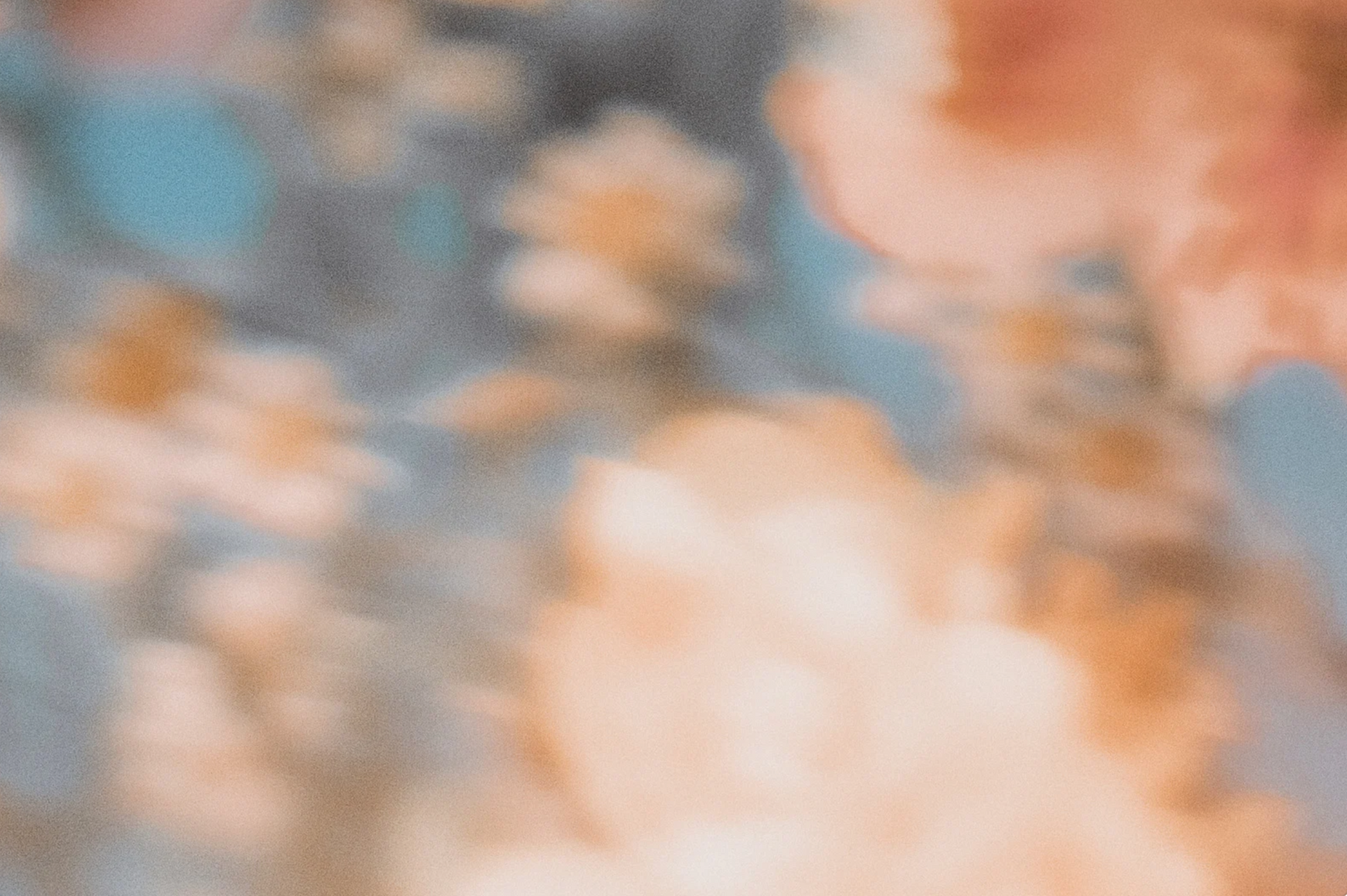 Soft, pastel-colored clouds. Peach and tan clouds against a light blue and grey background.