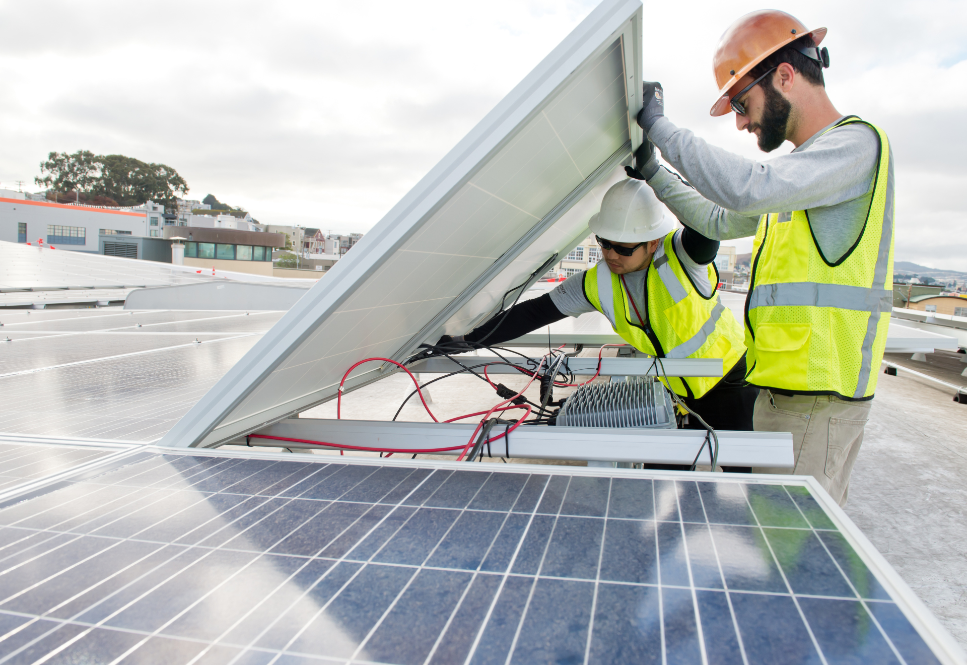 Two men are installing solar panels on a roof.